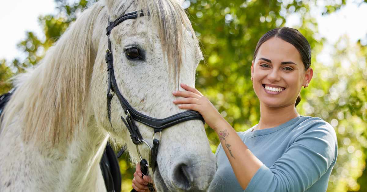 young woman standing with her horse young woman standing with her horse
