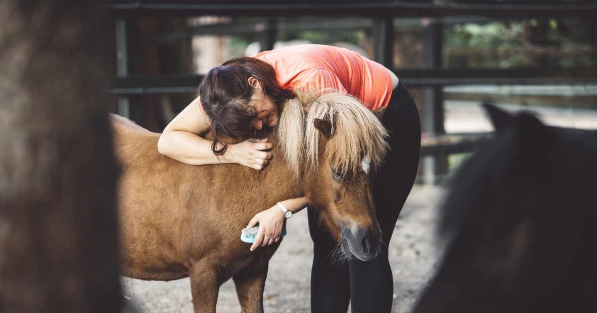 Woman hugging her little pony Woman hugging her little pony